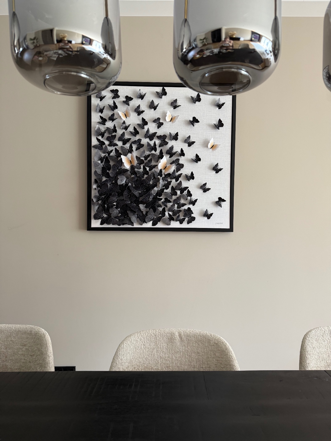 Wanddecoratie met zwarte vlinders boven eettafel